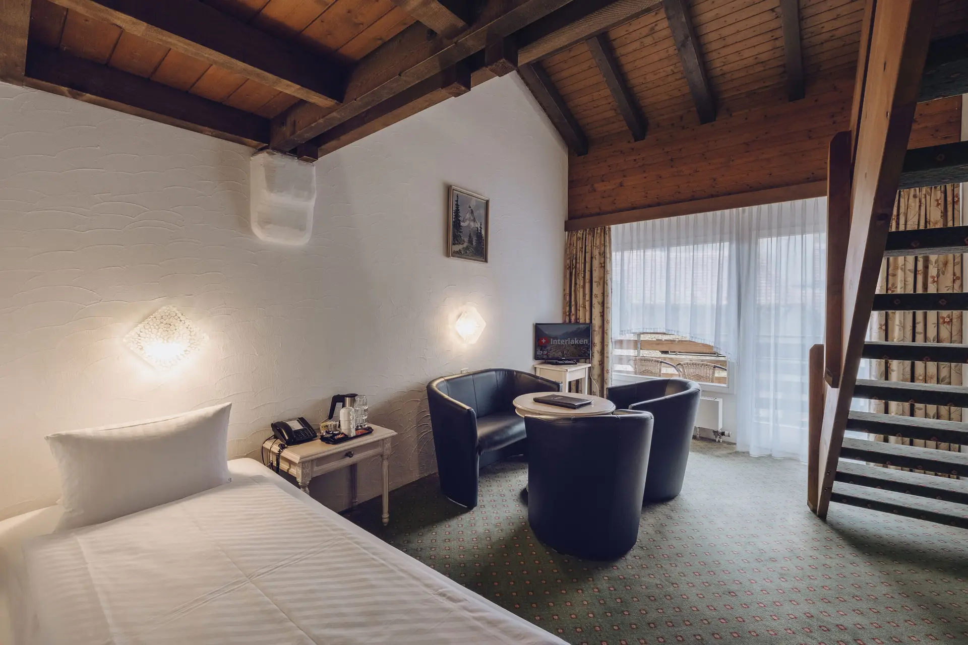 Ein geräumiges Familienzimmer im Hotel Chalet Swiss, einem Familienhotel in Interlaken, mit 3-4 Betten, traditionellem Schweizer Stil und warmer Atmosphäre – ideal für familienfreundliche Hotels in Interlaken, Photo by Matthias Dengler
