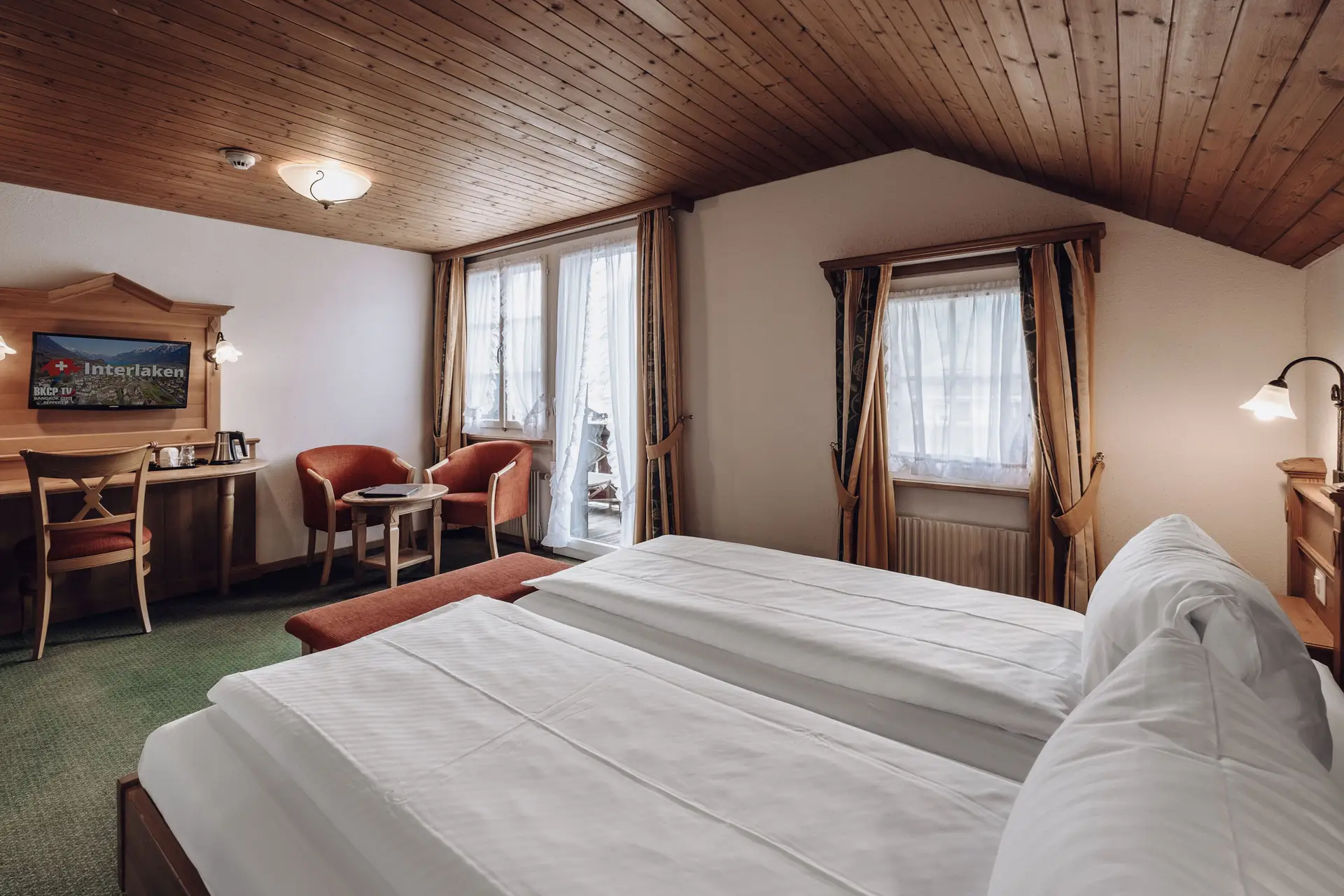 Superior room at Hotel Chalet Swiss in Interlaken withJungfraujoch Berner Oberland mountain view, elegant furnishings, and balcony access, Photo by Matthias Dengler