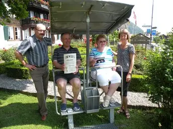 Peter und Deborah Clarke erhalten den Goldenen Schlüssel für 20 Jahre Treue zum Hotel Chalet Swiss, einem der ältesten Schweizer Chalets, von Gemeinderätin Ingrid Hofer am 1. Juli 2009.